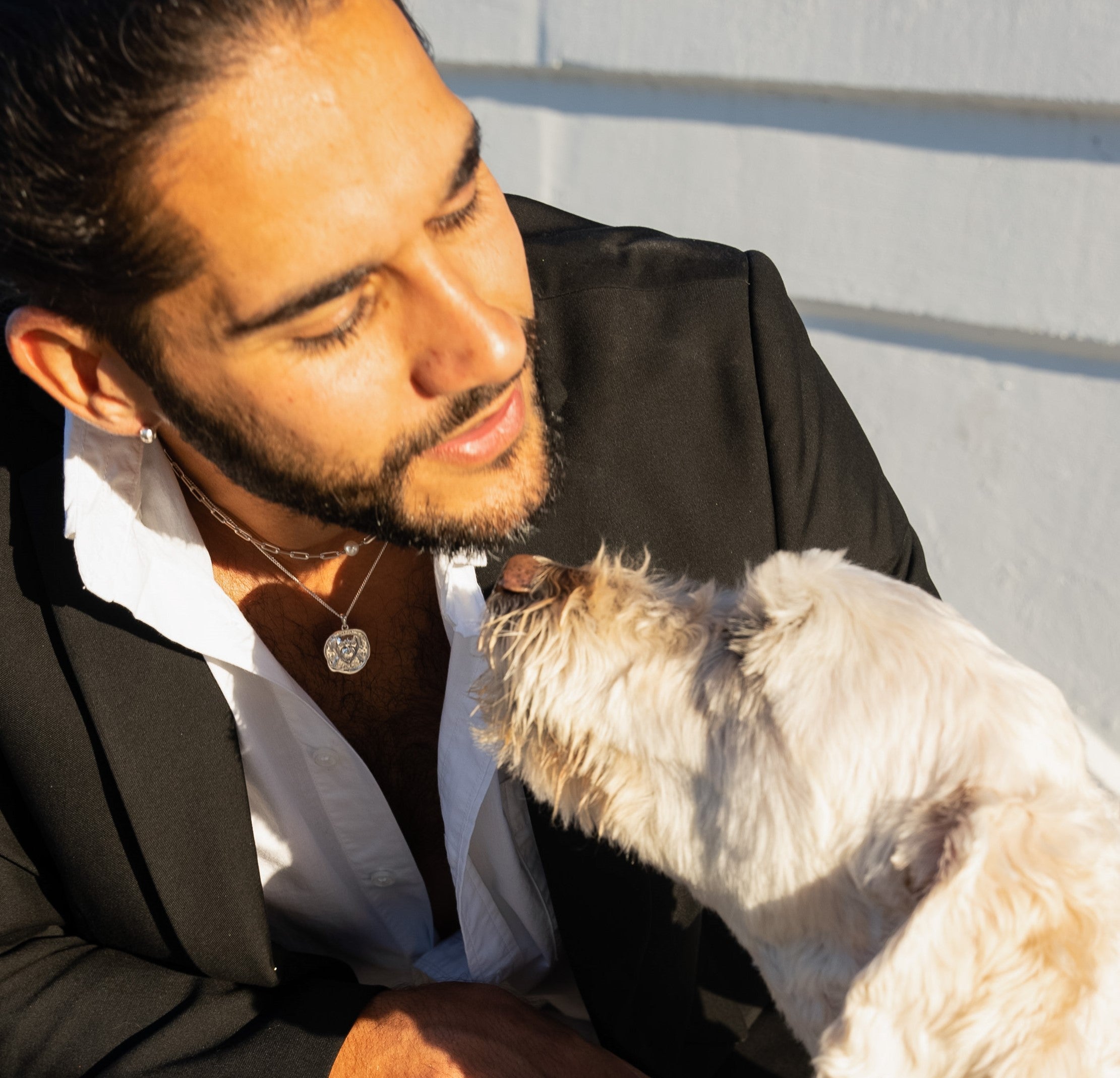 male model wearing FRENVYRN jewelry while petting dog