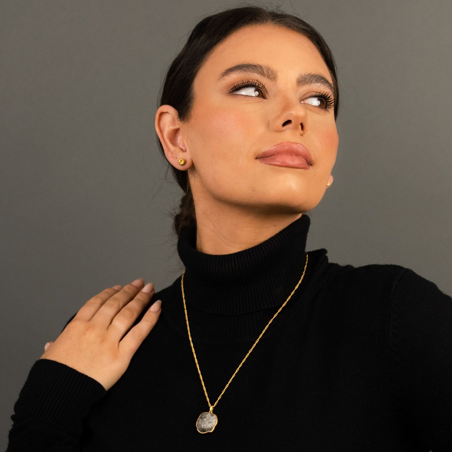 female model wearing the lars reversible dog coin necklace in 18k gold vermeil reversed, silver sheen obsidian, and the ren yarn stud earrings in 18k gold vermeil