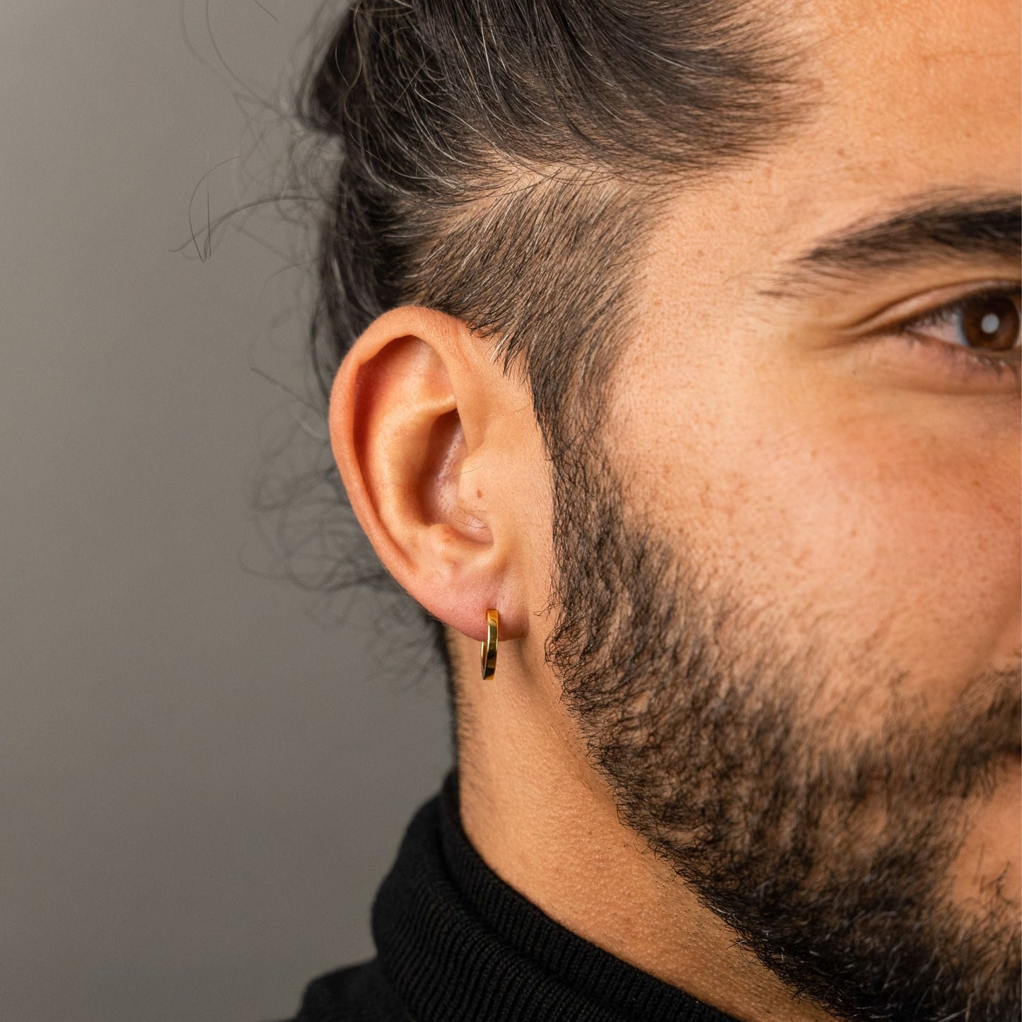 male model wearing the mars dog bone huggie hoop earring in 18k gold vermeil without the removable dog bone charm
