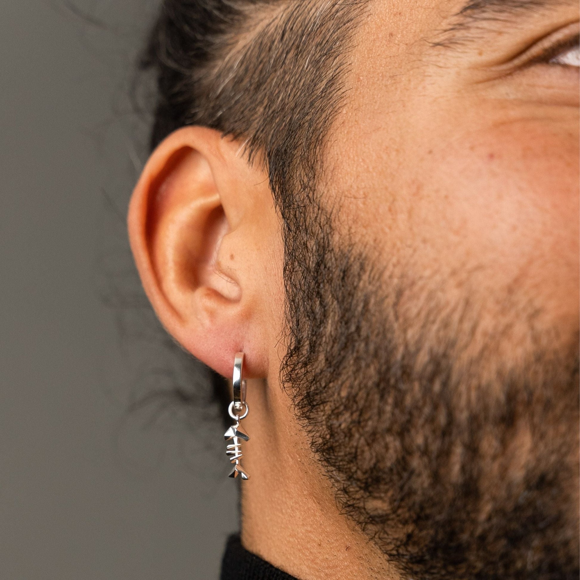 male model wearing the mars fish bone huggie hoop earring in sterling silver