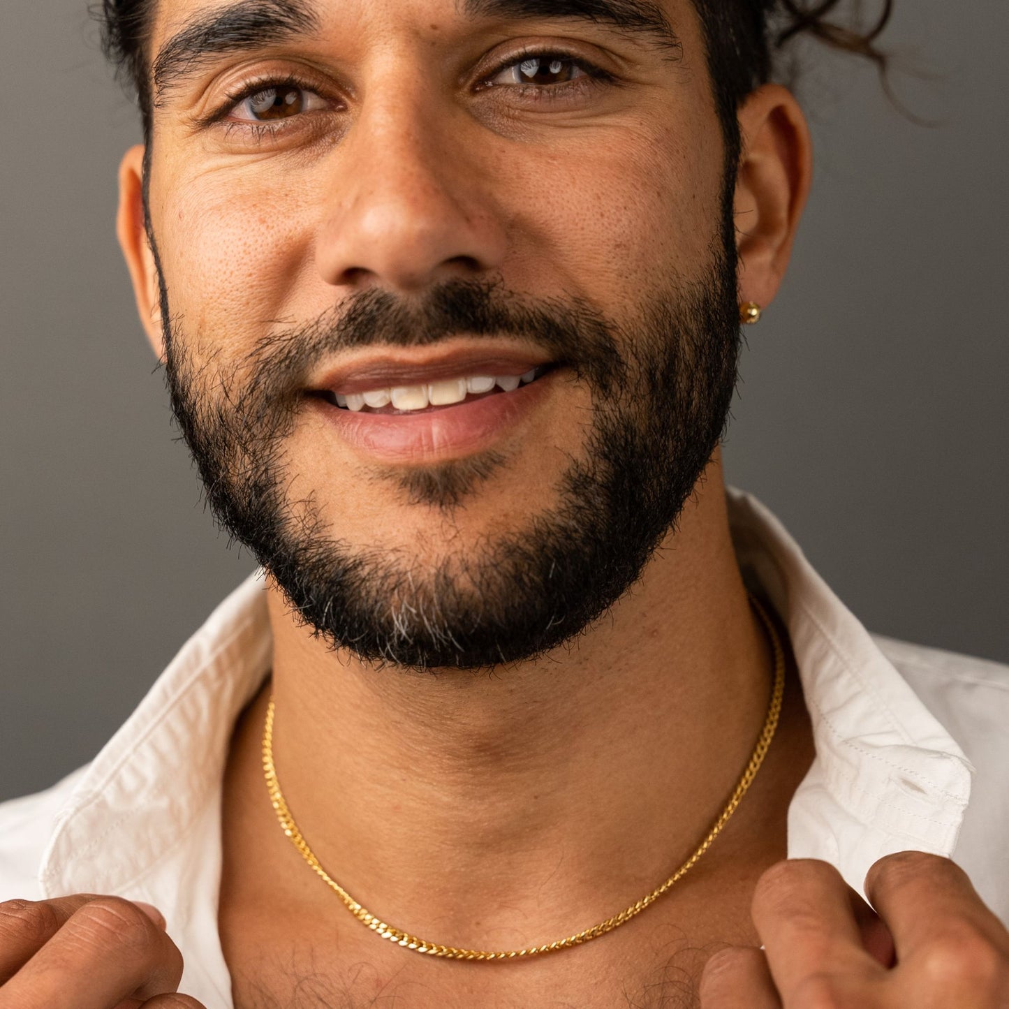 male model wearing the mars fish bone necklace in 18k gold vermeil chain detail view and the fran ball stud earring in 18k gold vermeil