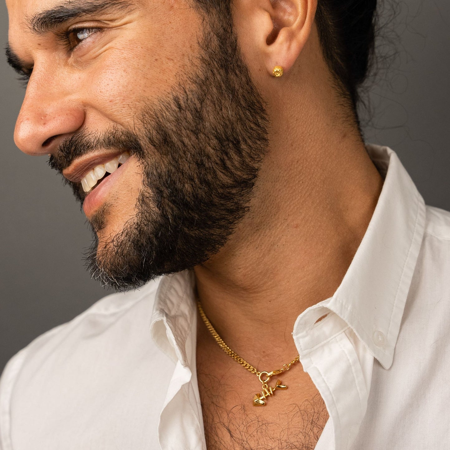 male model wearing the mars fish bone necklace in 18k gold vermeil and the ren yarn stud earring in 18k gold vermeil