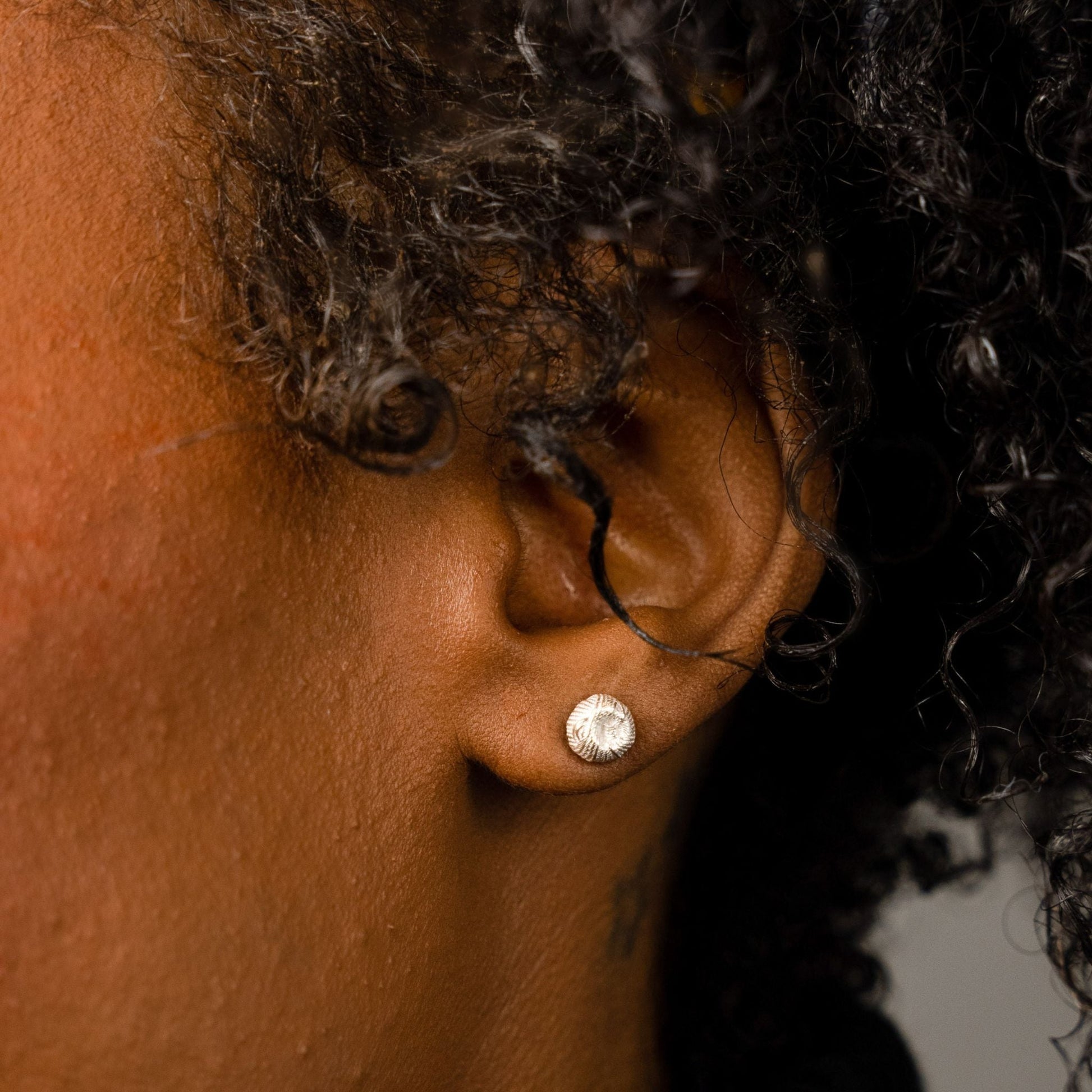 female model wearing the ren yarn stud earring in sterling silver