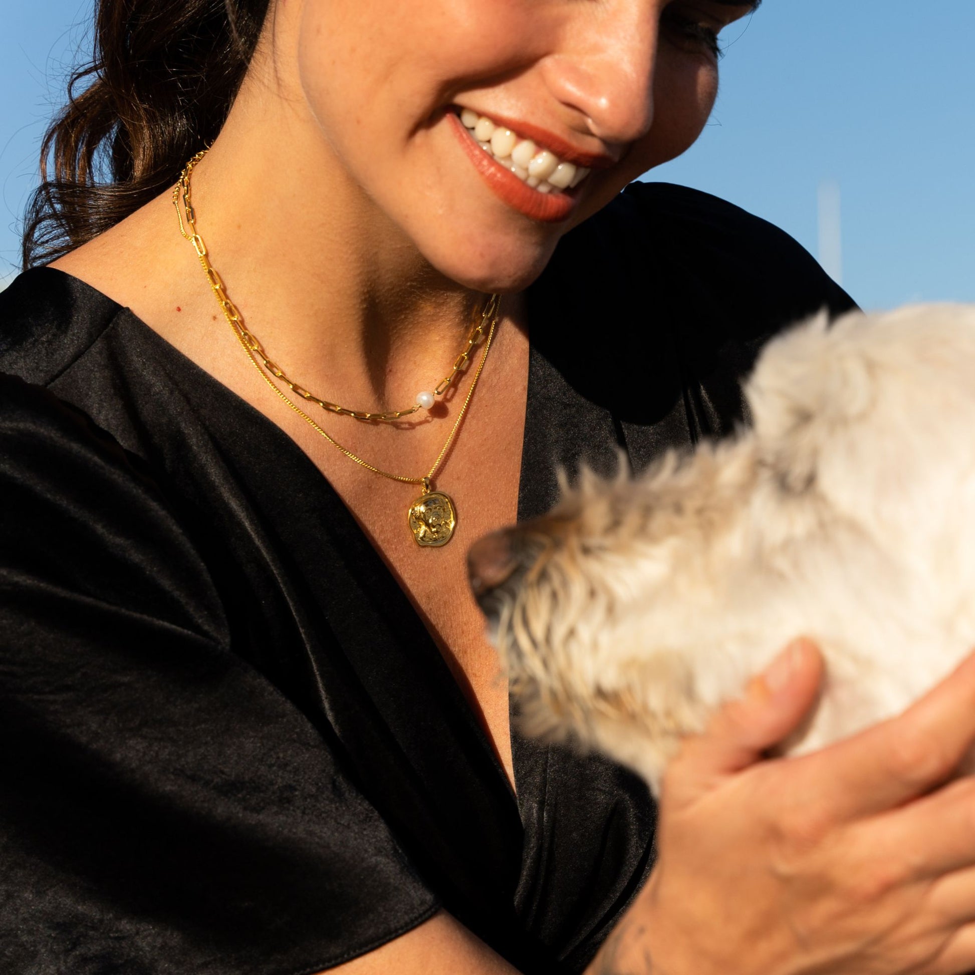 female model wearing the em mini paper clip pearl necklace in 18k gold vermeil and the lars dog coin necklace in 18k gold vermeil