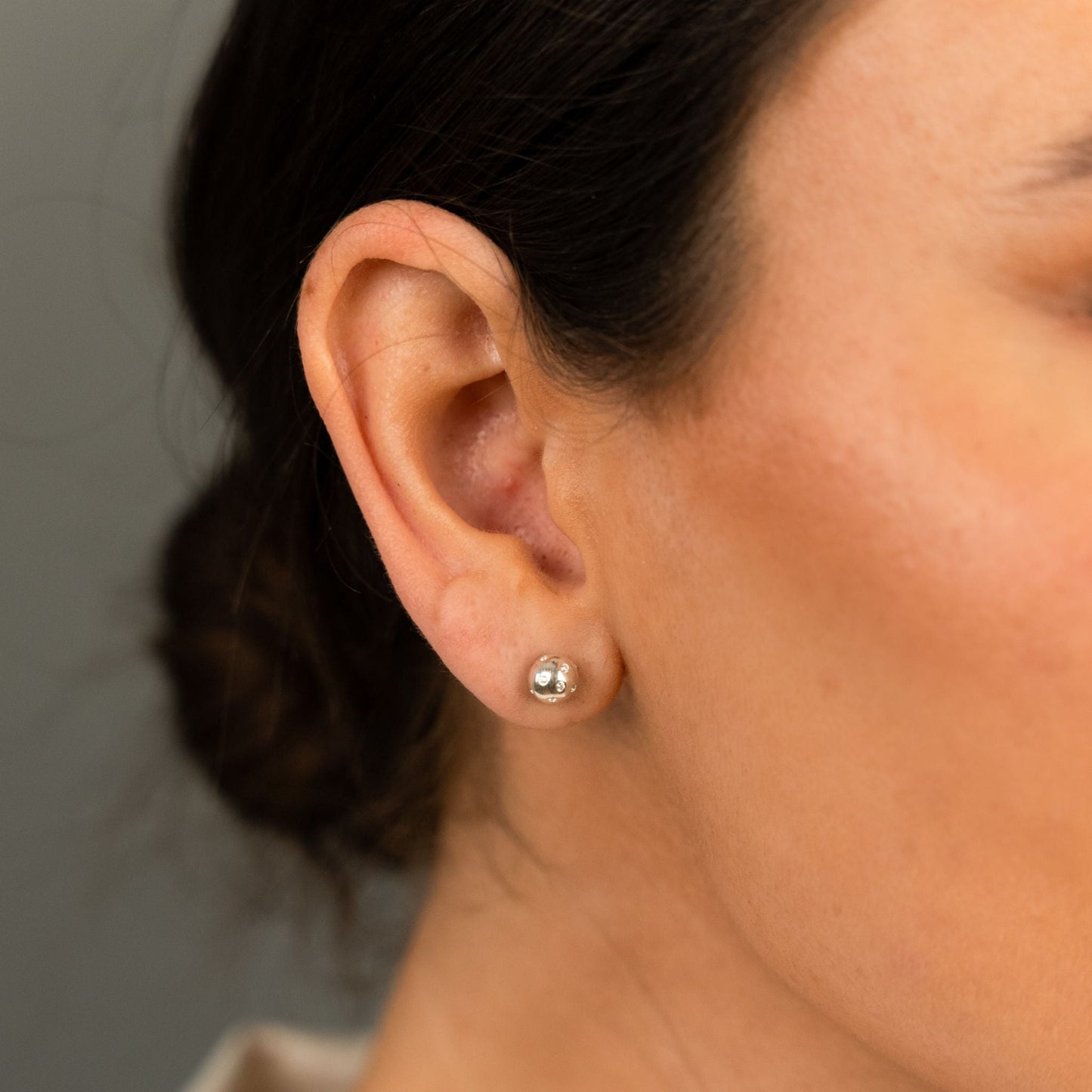 female model wearing the fran ball stud earring in sterling silver