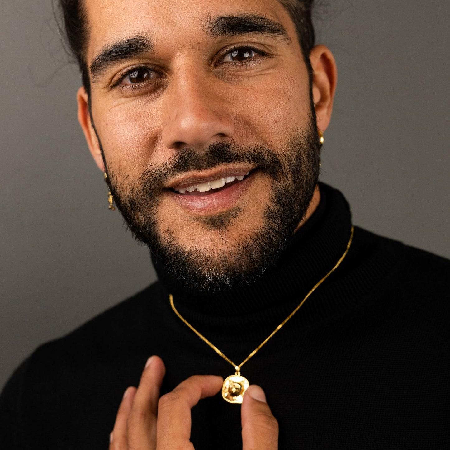 male model wearing the lars cat coin necklace in 18k gold vermeil and the mars fish bone huggie hoop earring in 18k gold vermeil