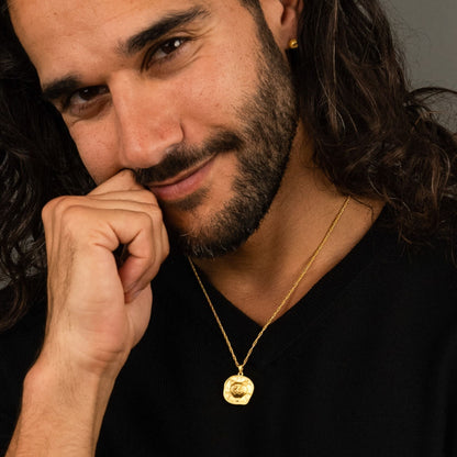 male model wearing the lars reversible cat coin necklace in 18k gold vermeil and the ren yarn stud earring in 18k gold vermeil