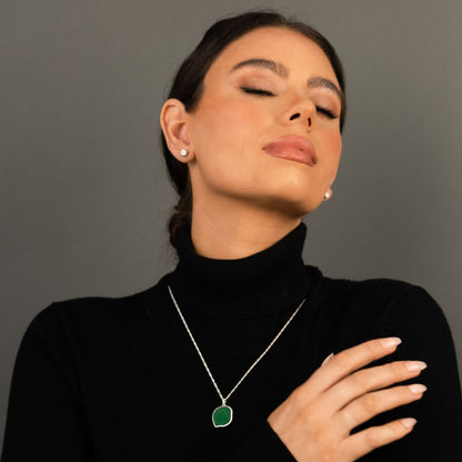 female model wearing the lars reversible cat coin necklace in sterling silver reversed, green aventurine, and the ren yarn stud earrings in sterling silver