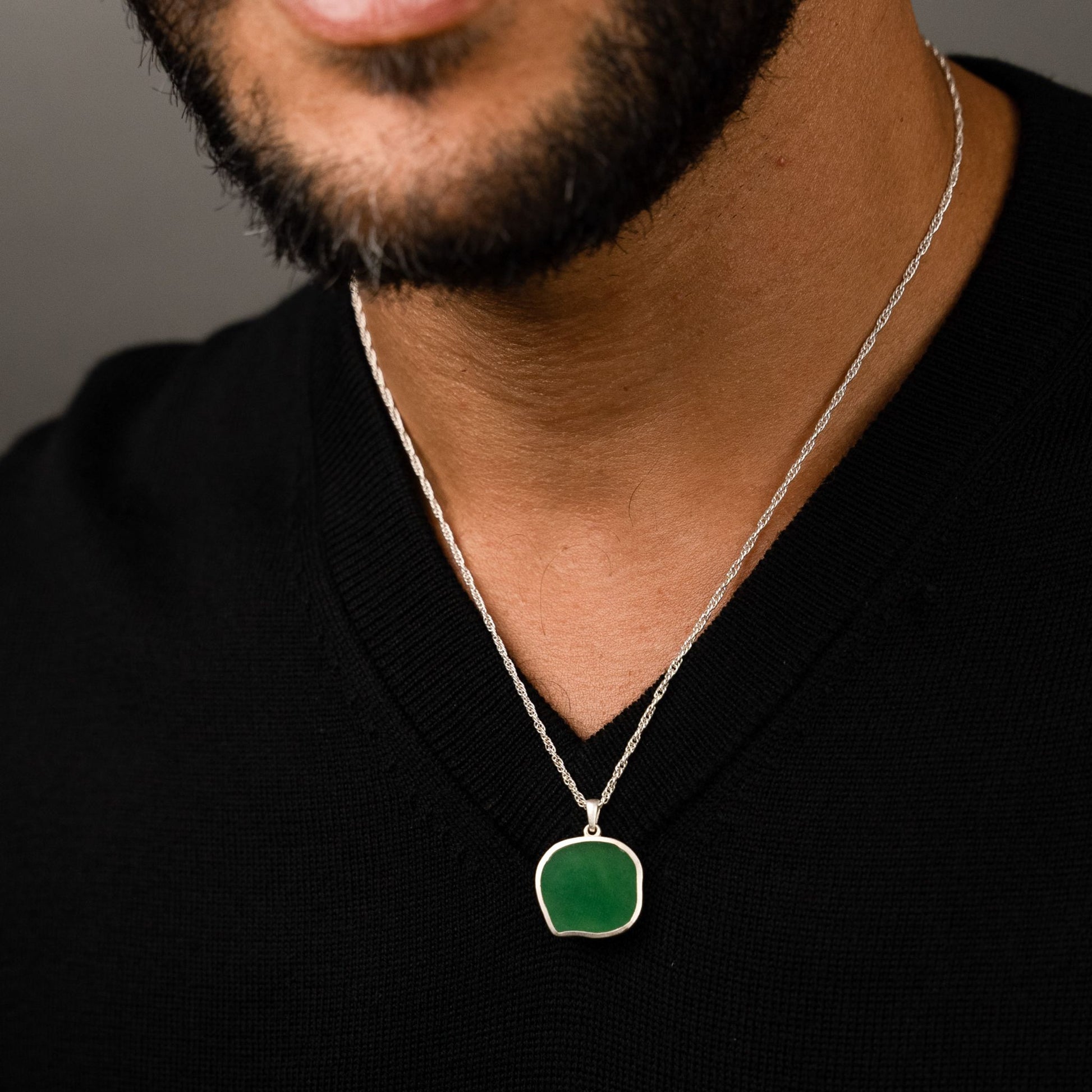 male model wearing the lars reversible cat coin necklace in sterling silver reversed, green aventurine
