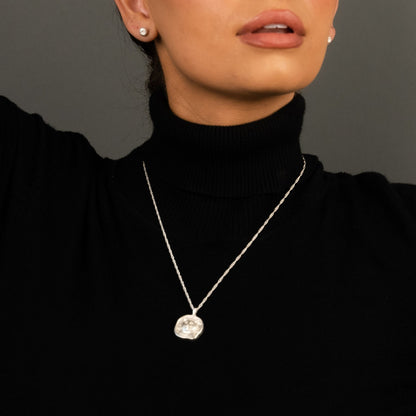 female model wearing the lars reversible cat coin necklace in sterling silver and the ren yarn stud earrings in sterling silver