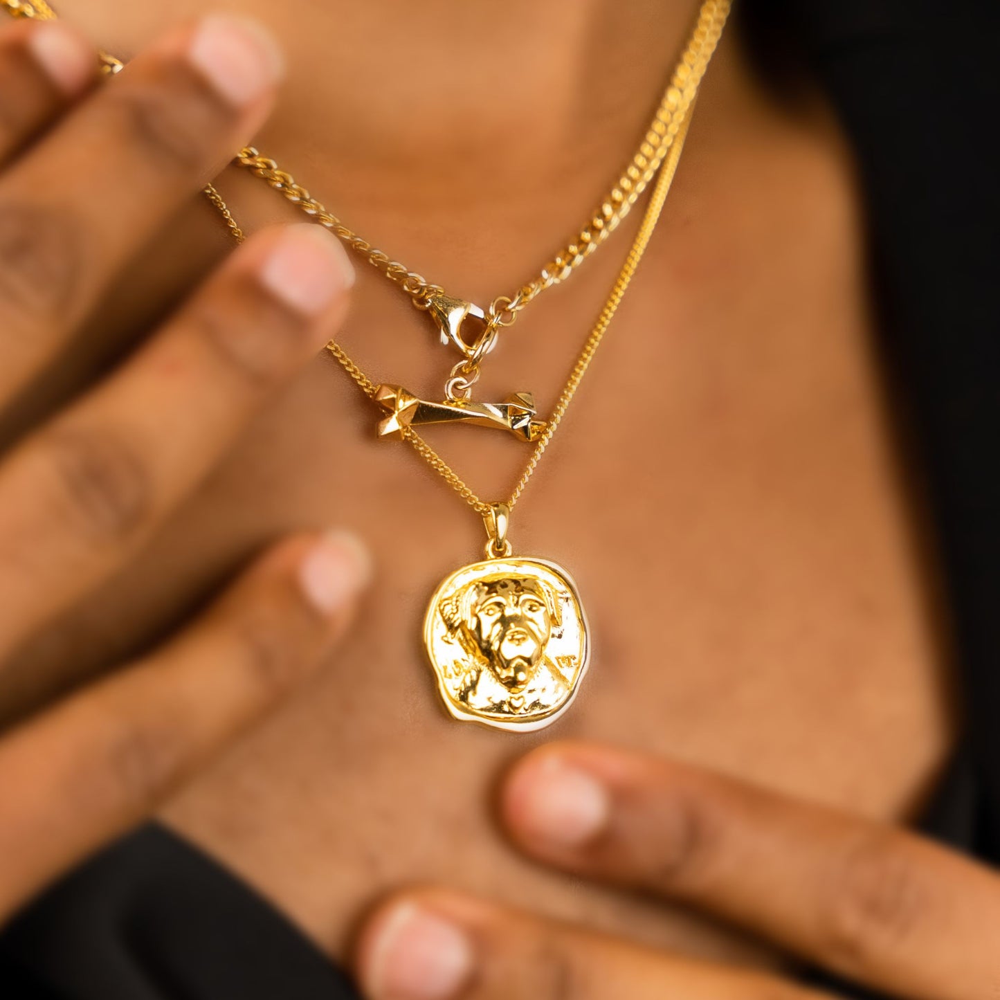 female model wearing the lars dog coin necklace in 18k gold vermeil and the mars dog bone necklace in 18k gold vermeil