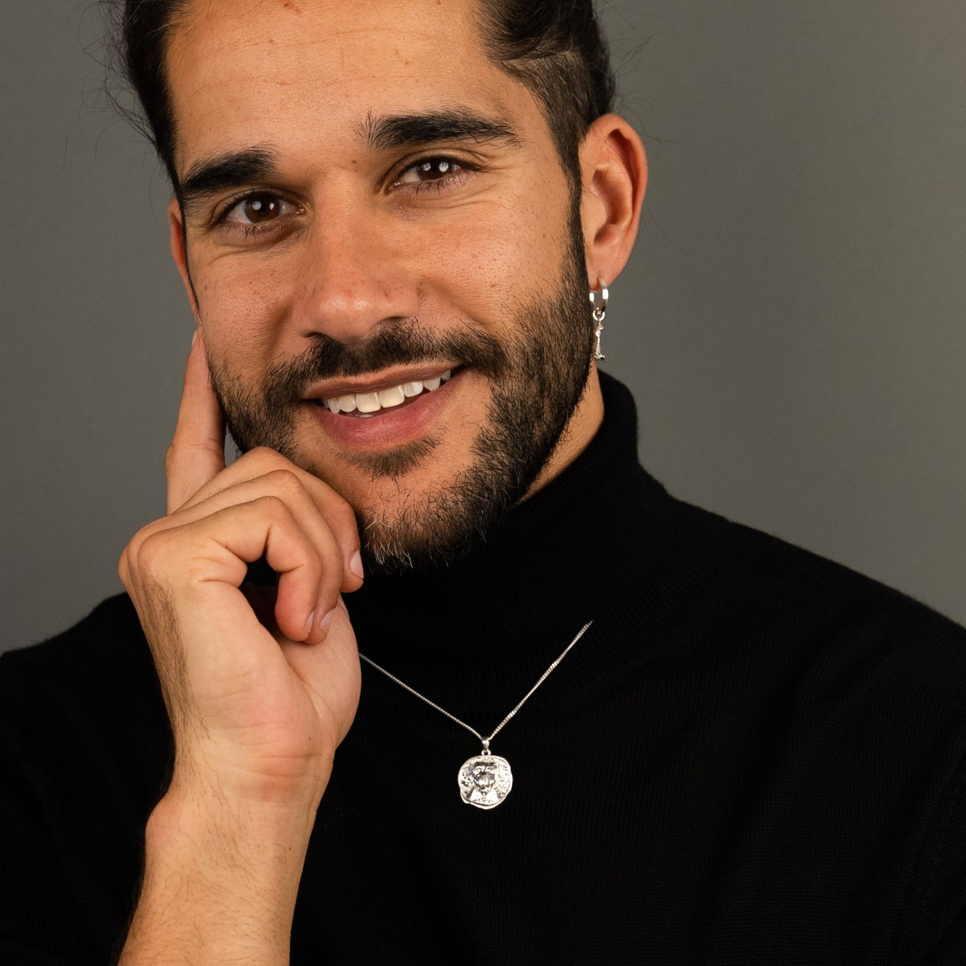 male model wearing the lars dog coin necklace in sterling silver and the mars dog bone huggie hoop earring in sterling silver