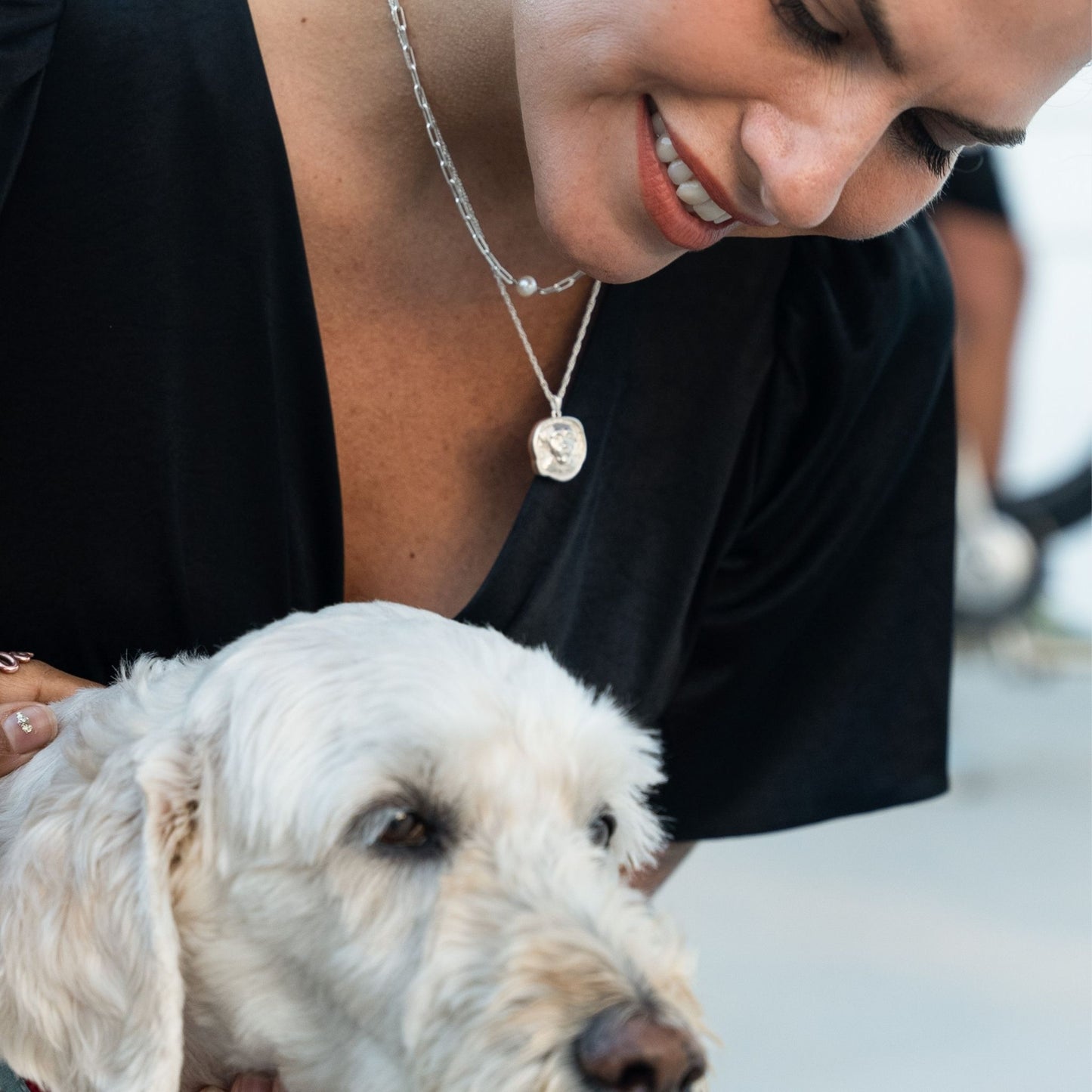 female model wearing the lars reversible dog coin necklace in sterling silver and the em mini paper clip pearl necklace in sterling silver