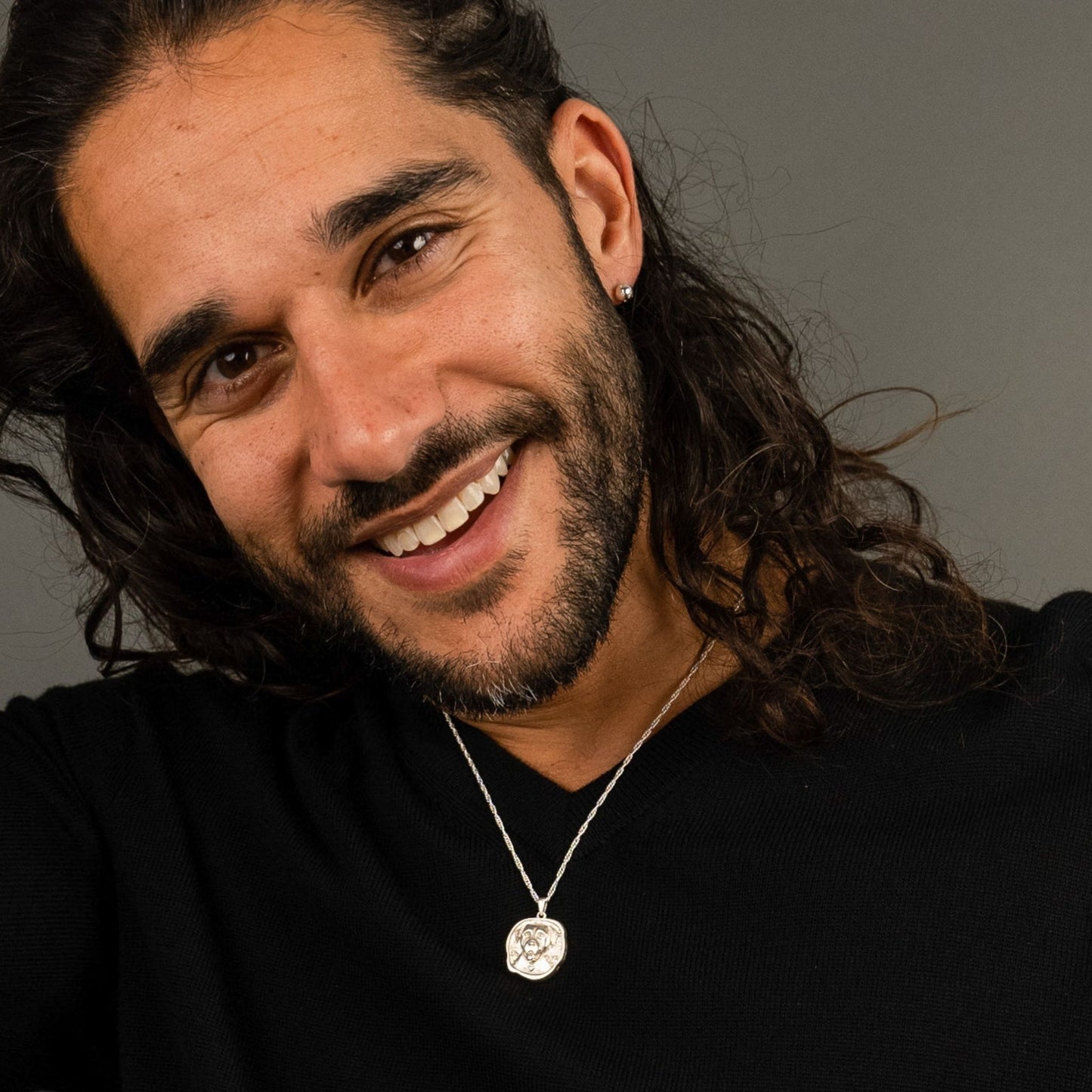 male model wearing the lars reversible dog coin necklace in sterling silver and the fran ball stud earring in sterling silver