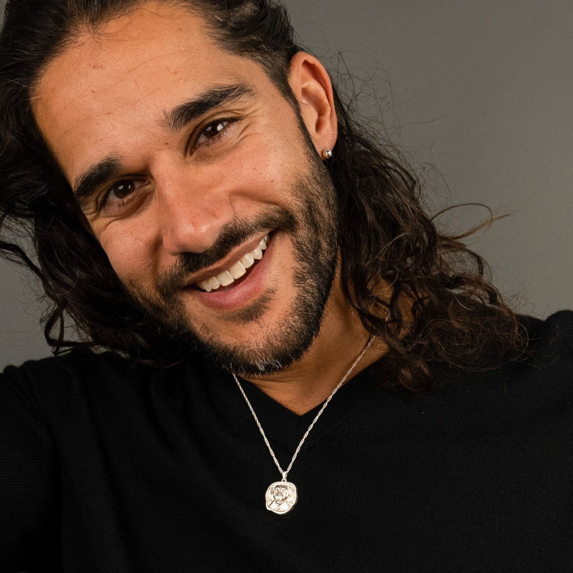 male model wearing the lars reversible dog coin necklace in sterling silver and the fran ball stud earring in sterling silver