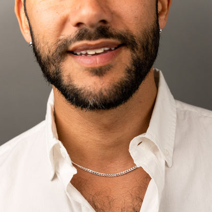 male model wearing the mars dog bone necklace in sterling silver chain detail view and the fran ball stud earrings in sterling silver