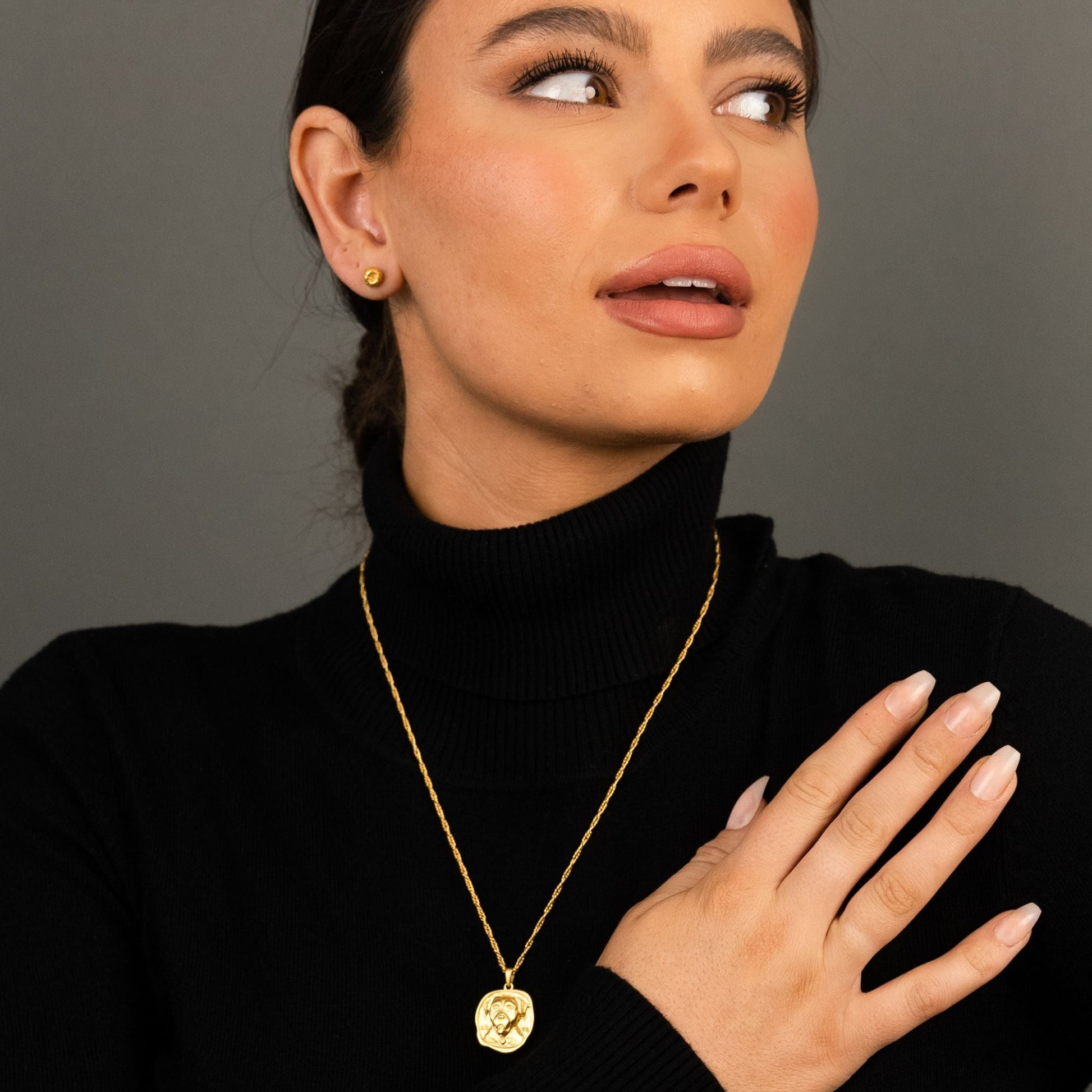female model wearing the ren yarn stud earring in 18k gold vermeil and the lars reversible dog medallion necklace in 18k gold vermeil